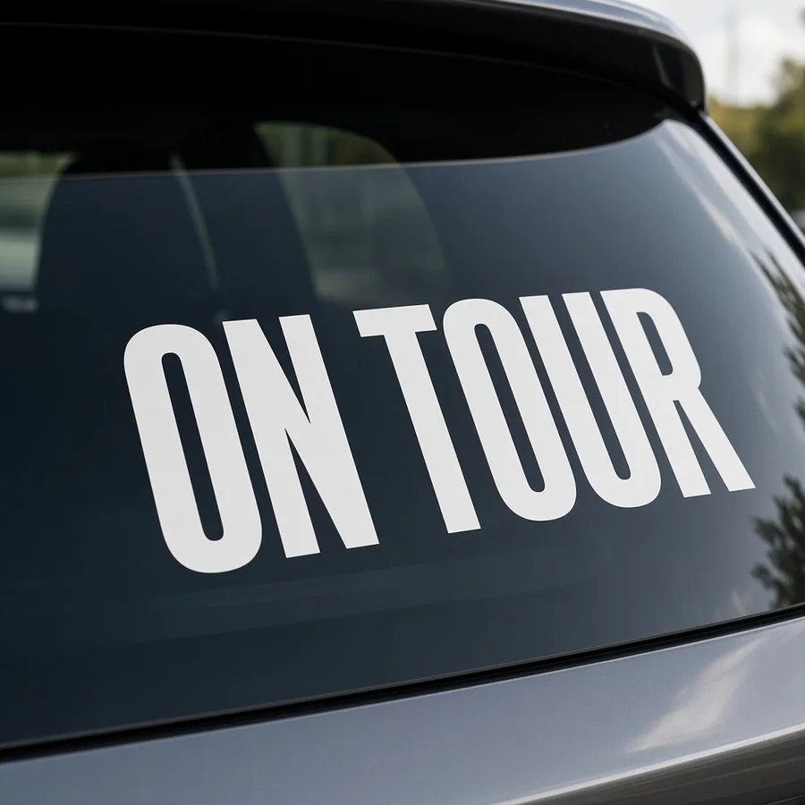 Weiße Klebebuchstaben ON TOUR auf der Heckscheibe