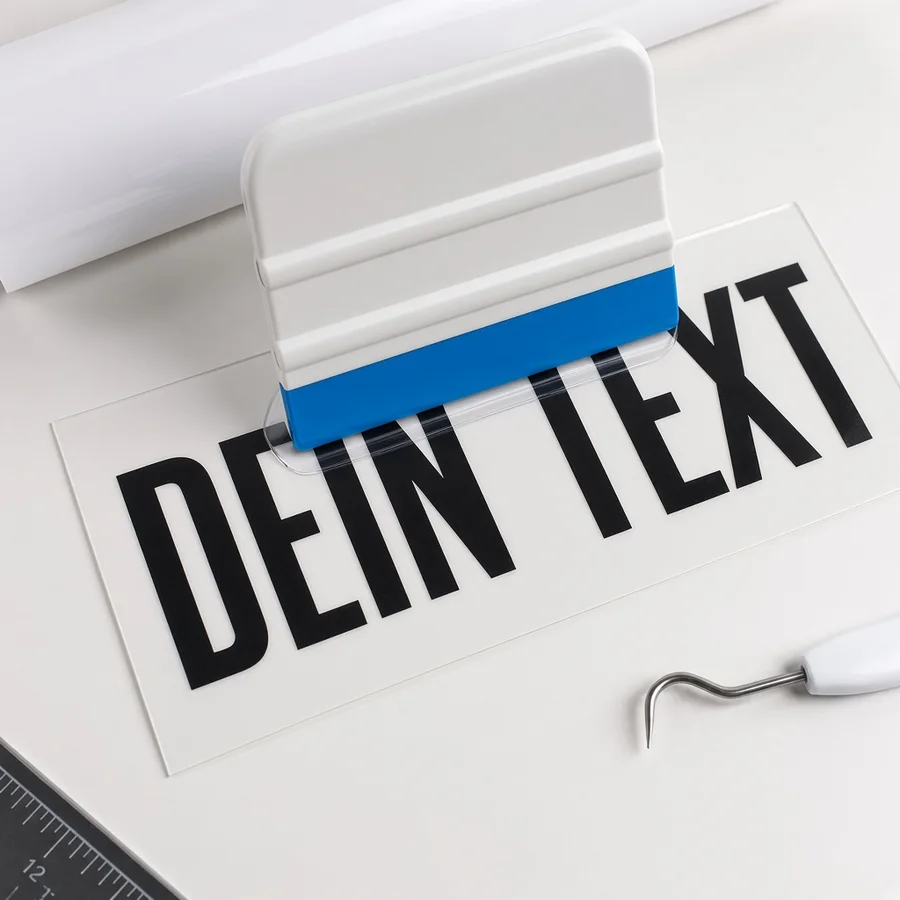 Rakel drückt Transferfolie auf geplottete Klebebuchstaben
